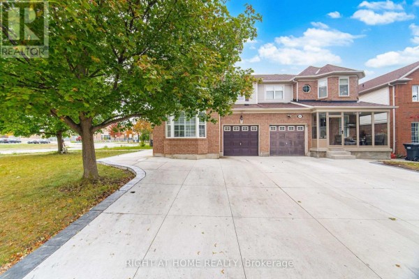 Driveway and garage doors of a brick house with a sunroom on the right. - 355 Brisdale Drive, Brampton