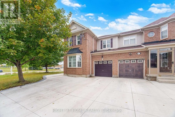 Close-up side view of a brick house showing garage doors and bay windows. - 355 Brisdale Drive, Brampton