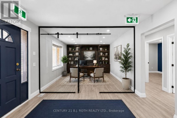 Interior view of entrance hall with dark blue door, glass partitions, and wood-look flooring. - 355 Mapleview Drive W, Barrie