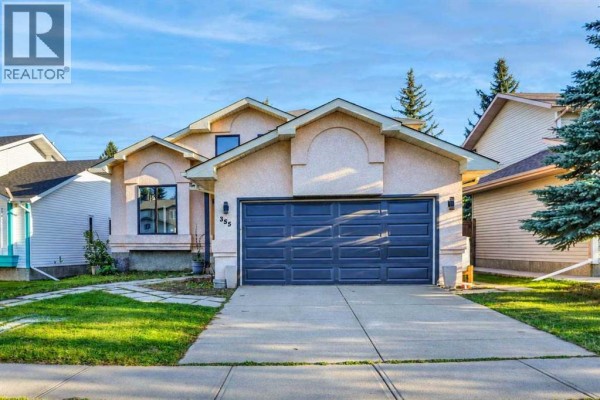 Exterior of a stucco house with a two-car garage and manicured lawn. - 355 Millrise Drive Sw, Calgary
