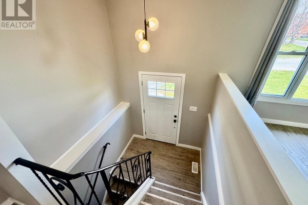 Small bathroom with a white pedestal sink, mirror, towel bar, and a cream-colored shower stall. - 356 Owens Crescent, Kingston
