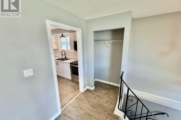 Unfinished basement room with wood laminate flooring, white walls, and a small window. - 356 Owens Crescent, Kingston