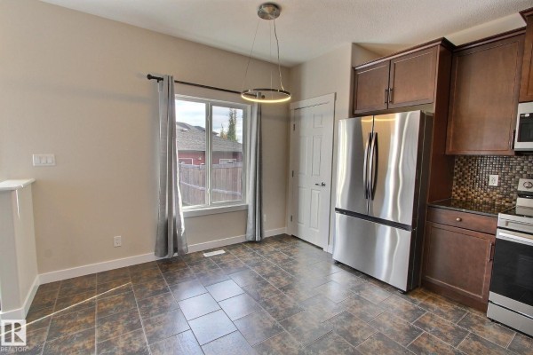 Bedroom with beige carpet, neutral walls, and a window with brown curtains. - 356 Pioneer Rd, Spruce Grove