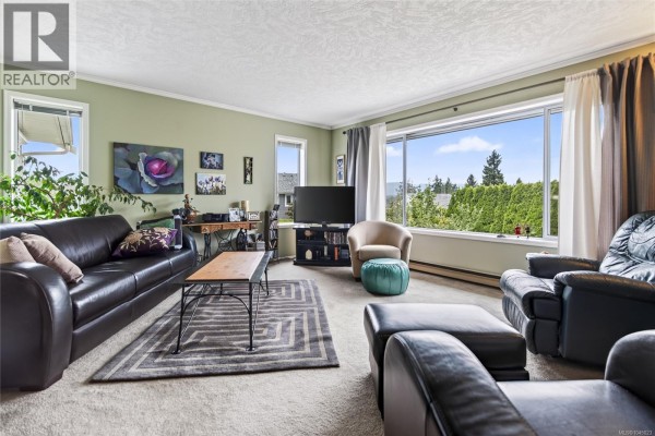 Living room with leather couches, carpet, and a large window with a view. - 356 Rees Rd, Courtenay