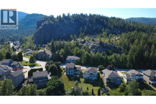 Snow-covered street view with mountains and homes under blue sky - 3583 14th Avenue, Castlegar