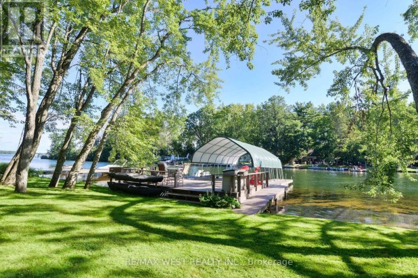 Covered boat dock with kayaks and seating on a waterfront property - 3587 Lauderdale Point Crescent Severn