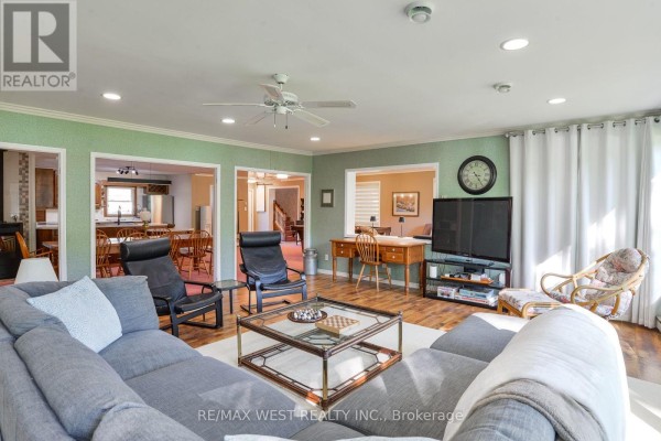 Living room with a sectional sofa, desk, and open doorways to other rooms. - 3587 Lauderdale Point Crescent, Severn