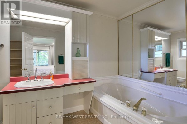 Bathtub and double vanity in a dated bathroom with mirrored walls - 3587 Lauderdale Point Crescent Severn