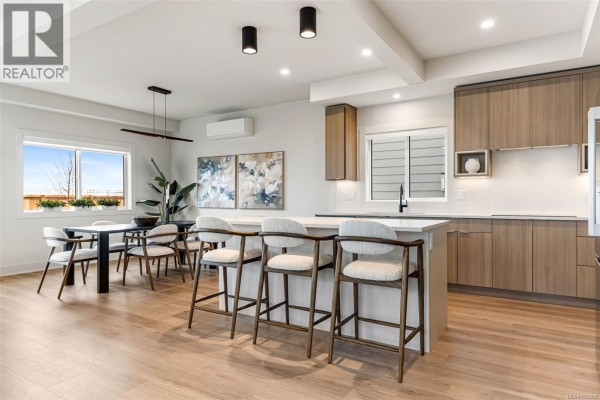 Kitchen with stainless steel appliances, white countertops, and warm wood cabinets. - 3587 Temperate Pl, Colwood