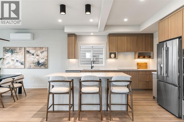 Close-up of the kitchen sink, dishwasher, and wood cabinetry with under-cabinet lighting. - 3587 Temperate Pl, Colwood