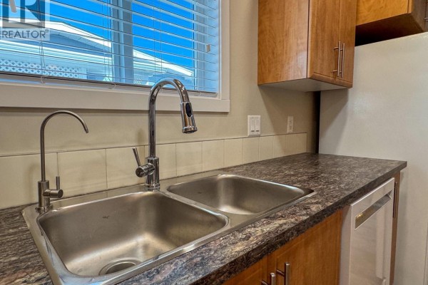 Close-up of a white gas range with four burners and a white oven. - 3591 Old Vernon Road Unit# 110b, Kelowna