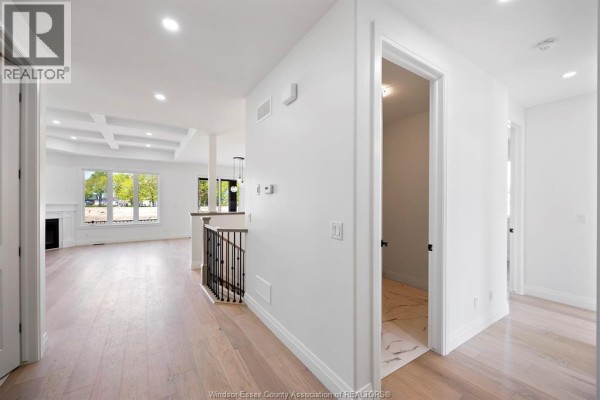 Hallway view into open concept living area with coffered ceiling and fireplace. - 3592 Sutton Avenue, Windsor