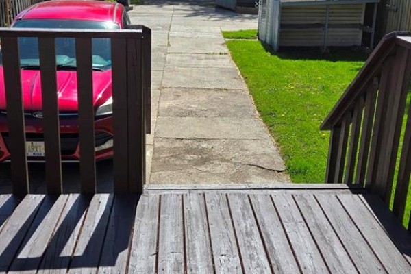 View from a wooden deck looking down at a concrete driveway with a red SUV. - 3595 Queen, Windsor