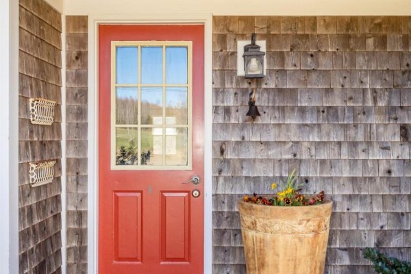 Red front door with glass panes, brass hardware, and a decorative lantern. - 3596 Clementsvale Road, Clementsvale