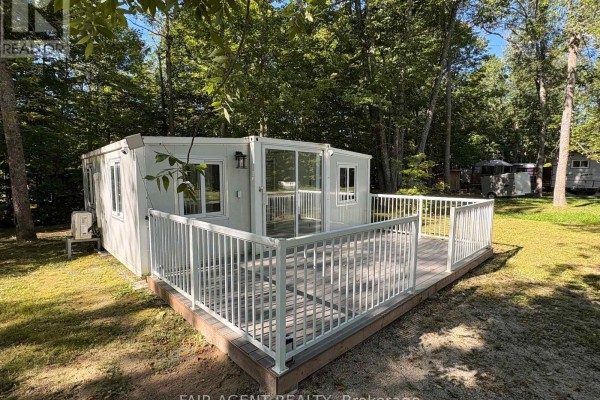 Close-up of the modern modular home's wooden deck with white railings and large windows. - 36 - 311 Cross Hill Road, Billings