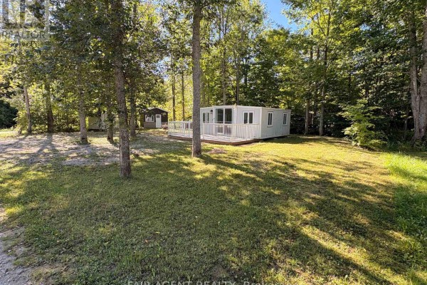 A wide shot of the property showcasing the modular home, cottage, shed, and natural landscape. - 36 - 311 Cross Hill Road, Billings