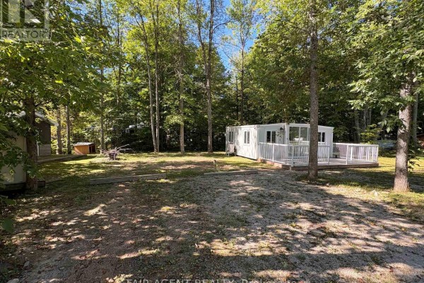 Sunny day view of the property with modular home, small cottage, and lush green trees. - 36 - 311 Cross Hill Road, Billings