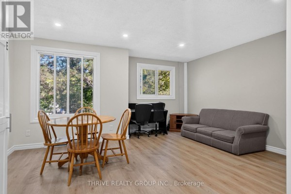 Living area with wooden table and chairs, a sofa, and a desk with two chairs. - 36 - 40 Summit Avenue, London North