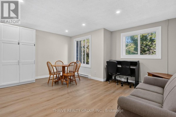 Room with light wood laminate flooring, white storage cabinets, a dining set, and a sofa. - 36 - 40 Summit Avenue, London North