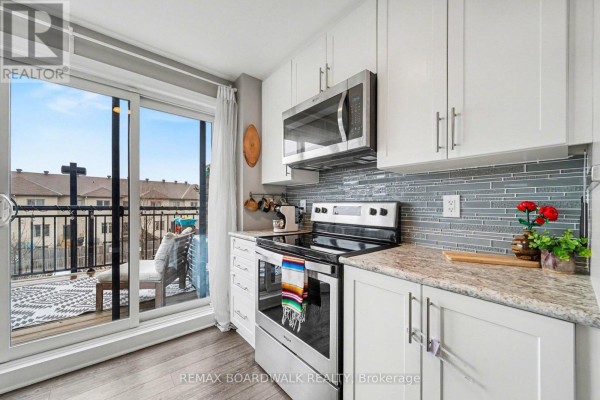 A modern kitchen with white cabinets, stainless steel appliances, and a balcony door. - 36 - 454 Via Verona Street, Ottawa