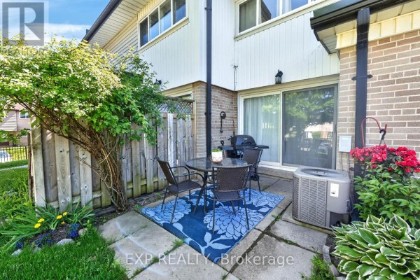 Small backyard patio with a table, chairs, grill, and air conditioning unit. - 36 - 925 Bayly Street, Pickering