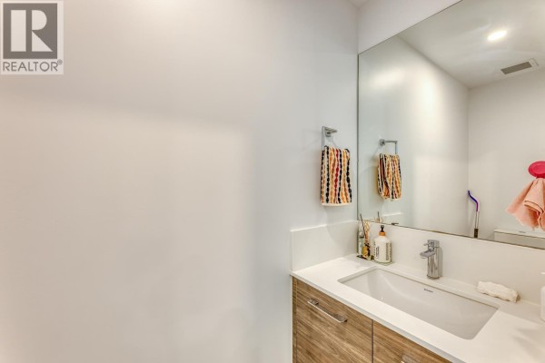 Powder room with white countertop, vessel sink, wood vanity, and mirror. - 36 10511 No. 5 Road, Richmond