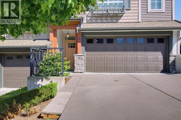 Close-up of a townhouse garage door and front entrance with stone pillar details. - 36 23539 Gilker Hill V2w 1c8 Road, Maple Ridge