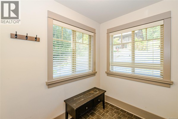 Interior view of entryway with two windows, bench, coat hooks, and tiled floor. - 36 315 Robinson Rd, Salt Spring