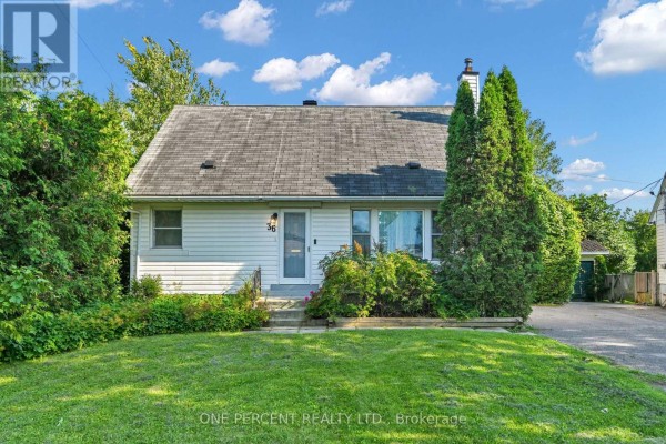 Front exterior of a white two-story house with a chimney and trees. - 36 Argue Drive, Ottawa
