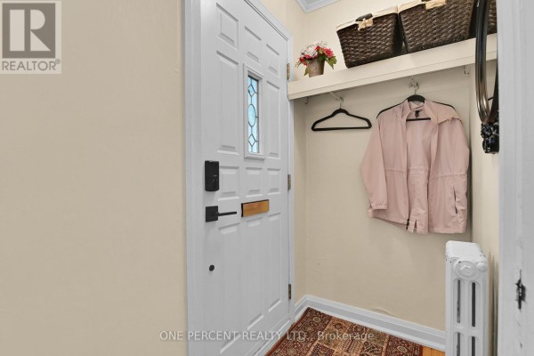 Interior entryway with a white door, storage baskets, and a radiator. - 36 Argue Drive, Ottawa