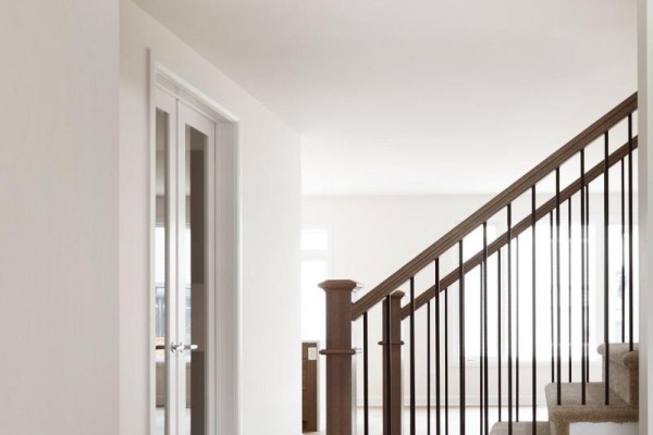 Interior hallway with white walls, a staircase with wood railing, and glass-paneled doors. - 36 Big Dipper Street, Ottawa