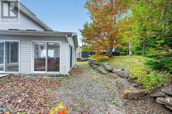 Gravel pathway beside a sunroom with sliding glass doors and a stone retaining wall. - 36 Bradmoor Crescent Crescent, Sydney River