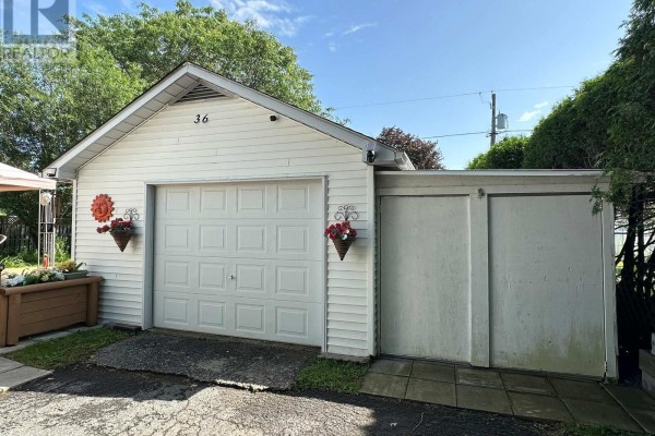 A detached single-car garage with a white sectional door and attached storage. - 36 Brouse Drive E, South Dundas