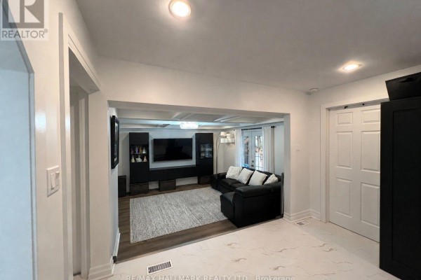 View into a living room with a sectional sofa, entertainment unit, and coffered ceiling from an adjacent room. - 36 Fergus Avenue N, Richmond Hill