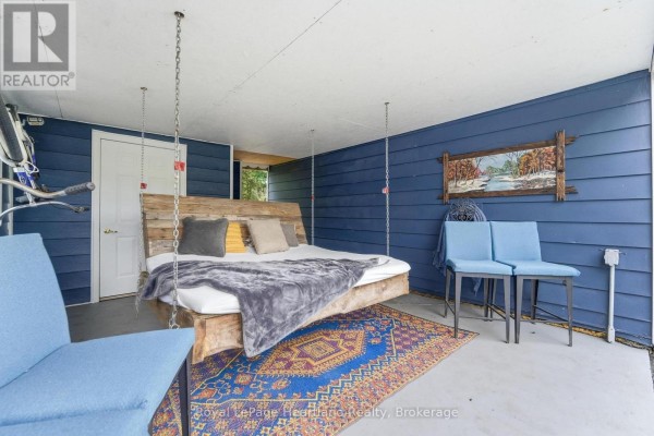 Outdoor covered space with hanging bed, blue chairs, and colorful rug. - 36 Jane Street, Bluewater