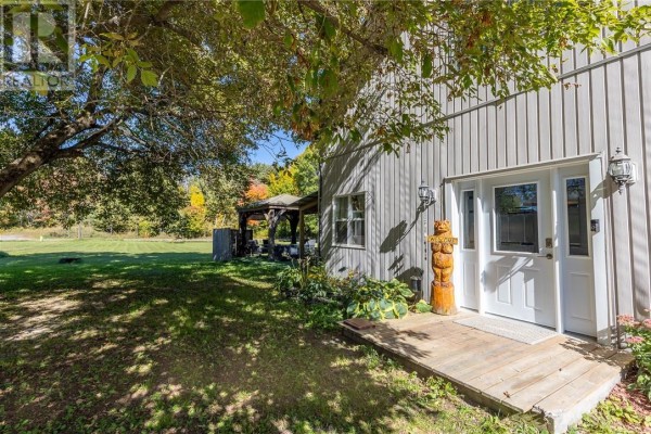 View of a wooden walkway leading to a white front door with glass panels and outdoor lighting. - 36 Mcintyre Street, Nairn Centre