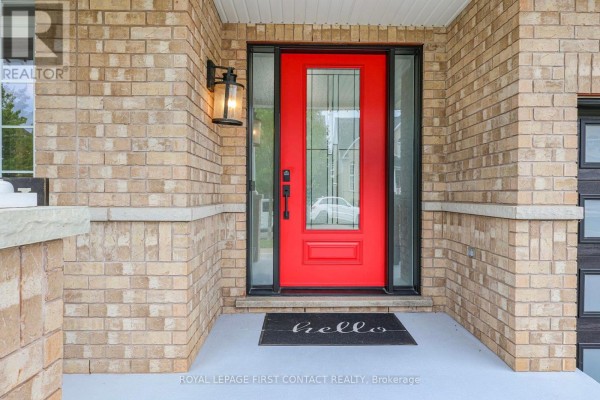 Close-up of a red front door with glass panels and a black lantern light. - 36 Regalia Way, Barrie