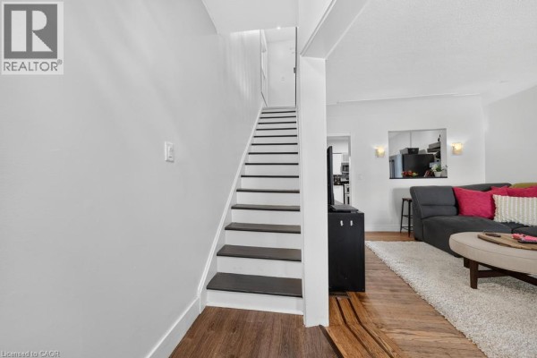 Interior view of a staircase with white risers and dark treads leading upstairs. - 36 Sherman Avenue N, Hamilton