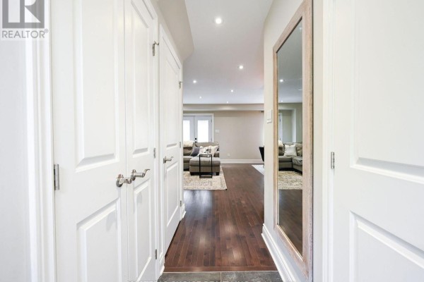 View from the hallway into a living area with dark hardwood floors and white trim. - 36 Sprucedale Court, Brampton