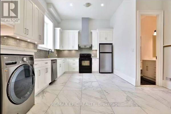 View of white cabinets, stainless steel appliances, and a laundry pair in a modern kitchen. - 36 Sussex Avenue, Richmond Hill