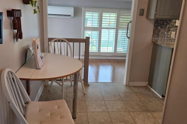 Small dining area with a table and chairs adjacent to a kitchen area. - 36 Weeping Willow Drive, Innisfil