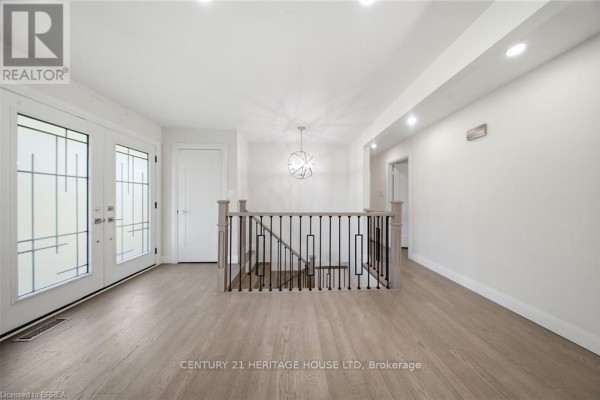 Spacious interior hallway with light wood flooring, white walls, and a modern chandelier. - 360 Bishopsgate Road, Brant