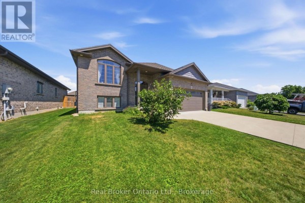 Side view of a brick house with a sloped lawn and mature trees. - 360 Dover Avenue, Norfolk
