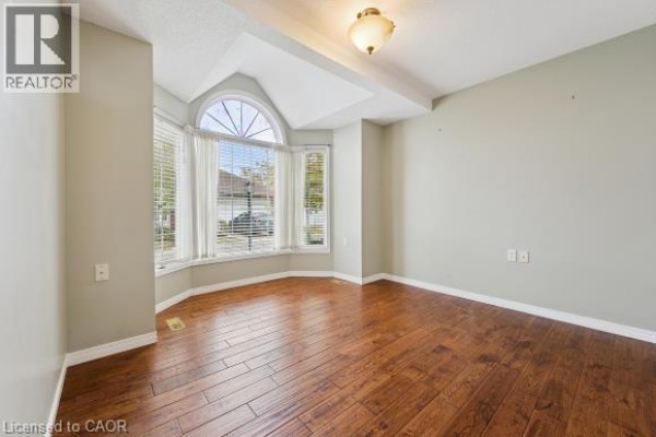 Living room with a large bay window, hardwood floors, and light green walls. - 360 Erbsville Road Unit# 18, Waterloo