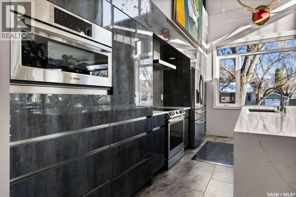 Entryway with gray walls, storage bench, and wall-mounted coat hooks - 3601 Grassick Avenue, Regina