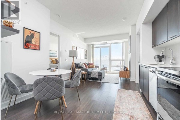 Open-concept living and dining area with a round table, four chairs, sofa, and large window. - 3602 - 2212 Lake Shore Boulevard, Toronto