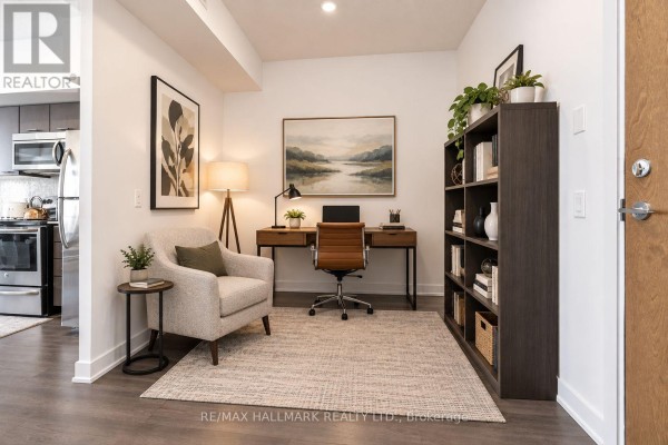 Home office with a desk, chair, bookshelf, armchair, and artwork on a light grey rug. - 3602 - 2212 Lake Shore Boulevard, Toronto