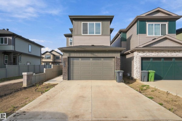 Exterior front view of a modern two-story house with a gray garage door and stone accents. - 3602 41 Ave, Beaumont