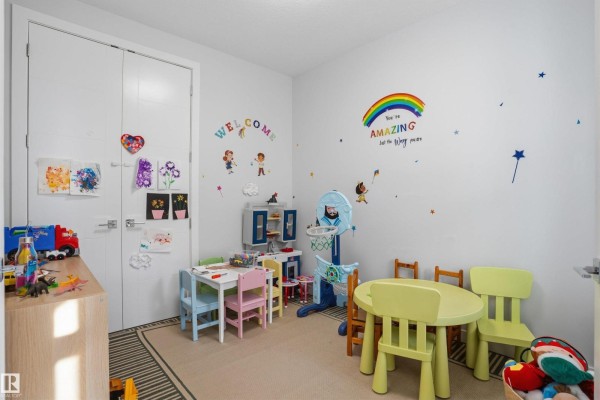 Children's playroom with a small table and chairs, toys, a mini basketball hoop, and colorful wall decals. - 3602 41 Ave, Beaumont