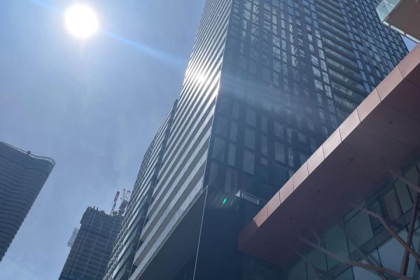 Low angle view of a modern skyscraper on a sunny day with lens flare. - 3604 - 28 Wellesley Street E, Toronto